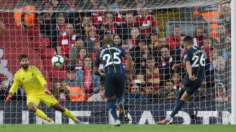 Gelandang Manchester City, Riyad Mahrez melakukan tendangan penalti tetapi gagal mencetak gol selama pertandingan sepak bola Liga Inggris antara Liverpool melawan Manchester City di Stadion Anfield, Liverpool, Inggris, Minggu (7/10). [AFP/Paul ELLIS]