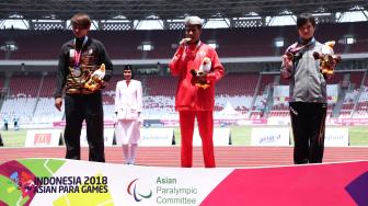 Atlet Indonesia Rica Oktavia (tengah) bersama Atlet Malaysia Siti Noor Radiah (kiri) dan Atlet Jepang Sakai Sonomi (kanan) berpose seusai menerima medali para atletik nomor lompat jauh putri T20 Asian Para Games 2018 di Stadion Utama GBK, Jakarta, Senin (8/10). [Suara.com/Muhaimin A Untung]
