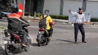 Sejumlah Petugas Dishub melakukan sosialisasi uji Coba Sistem satu arah Jalan KH Wahid Hasyim, Jakarta Pusat, Senin (8/10). [Suara.com/Fakhri Hermansyah]