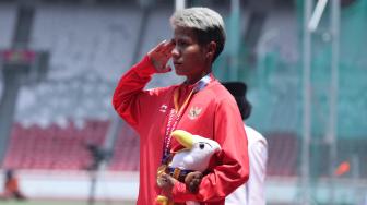 Atlet Indonesia Rica Oktavia memberikan hormat seusai menerima medali para atletik nomor lompat jauh putri T20 Asian Para Games 2018 di Stadion Utama GBK, Jakarta, Senin (8/10). [Suara.com/Muhaimin A Untung