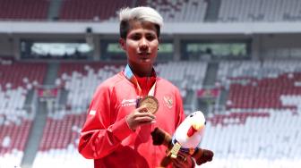 Atlet Indonesia Rica Oktavia berpose seusai menerima medali para atletik nomor lompat jauh putri T20 Asian Para Games 2018 di Stadion Utama GBK, Jakarta, Senin (8/10). [Suara.com/Muhaimin A Untung]