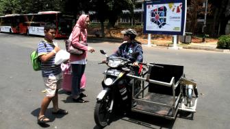 Driver Ojek Disabilitas menawarkan jasa kepada pengunjung di Kompleks Gelora Bung Karno,Senayan,Jakarta Pusat (8/10). [Suara.com/Fakhri Hermansyah]
