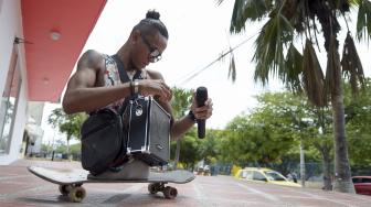 Alfonso Mendoza (Alca) bersiap-siap sebelum berangkat untuk tampil di bus, Barranquilla, Kolombia, Jumat (28/9). [AFP/ARBOLDA]
