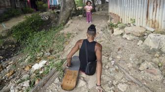 Alfonso Mendoza (Alca) menuju ke rumahnya setelah tampil di bus, Barranquilla, Kolombia, Jumat (28/9). [AFP/ARBOLDA]
