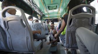 Alfonso Mendoza (Alca) saat menghibur penumpang di dalam bus, Barranquilla, Kolombia, Jumat (28/9). [AFP/ARBOLDA]