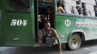 Alfonso Mendoza (Alca) turun dari bus setelah tampil di dalam bus, Barranquilla, Kolombia, Jumat (28/9). [AFP/ARBOLDA]