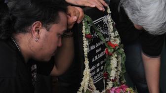 Putra Indro Warkop Harley Triandro saat berdoa didepan nisan Almarhumah Nita Octobijanthy di TPU Tanah Kusir, Jakarta Selatan, Rabu (10/10). (Suara.com/Fakhri Hermansyah)