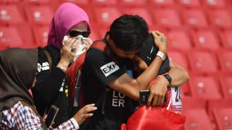 Sprinter Indonesia Karisma Evi Tiarani (kanan) dipeluk keluarganya usai finis terdepan dalam nomor 100 meter putri T42 dan T63 Asian Para Games 2018 di Stadion Utama Gelora Bung Karno, Jakarta, Rabu (10/10). [ANTARA FOTO/Akbar Nugroho Gumay]