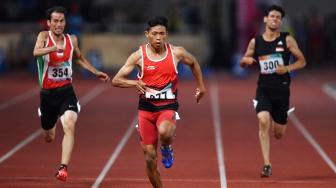 Sprinter Indonesia Sapto Yogo Purnomo (tengah) berlari dalam final 100 meter putra T37 Asian Para Games di Stadion Utama Gelora Bung Karno, Senayan, Jakarta, Selasa (9/10). [ANTARA FOTO/Sigid Kurniawan]
