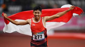 Sprinter Indonesia Sapto Yogo Purnomo mengibaskan bendera Merah-Putih usai menjuarai final 100 meter putra T37 Asian Para Games di Stadion Utama Gelora Bung Karno, Senayan, Jakarta, Selasa (9/10). [ANTARA FOTO/Sigid Kurniawan]
