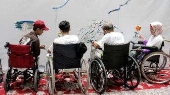 Penyandang disabilitas melukis di kanvas di Balai Agung, Jakarta, Kamis (11/10). (Suara.com/Fakhri Hermansyah)