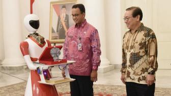 Gubernur DKI Jakarta Anies Baswedan berinteraksi dengan robot usai menandatangani MOU kerja sama tentang teknologi robotik  di provinsi DKI Jakarta di ruang Balairung, Balai Kota,Jakarta Pusat, Kamis (11/10). (Suara.com/Fakhri Hermansyah) 