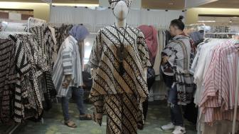 Pengunjung mengamati busana batik pada pameran Crafina di JCC, Senayan, Jakarta Pusat, Minggu (14/10). (Suara.com/Fakhri Hermansyah)