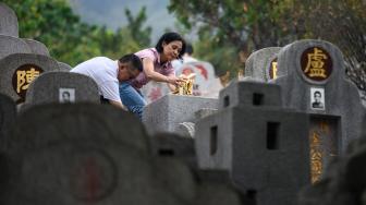 Warga mengunjungi makam kerabat saat Festival Chung Yeung atau juga dikenal Tomb Sweeping Day di sebuah pemakaman di Hong Kong, Rabu (17/10). [AFP/Anthony WALLACE]