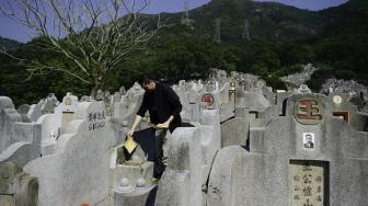 Warga mengunjungi makam kerabat saat Festival Chung Yeung atau juga dikenal Tomb Sweeping Day di sebuah pemakaman di Hong Kong, Rabu (17/10). [AFP/Anthony WALLACE]