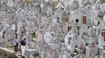 Warga mengunjungi makam kerabat saat Festival Chung Yeung atau juga dikenal Tomb Sweeping Day di sebuah pemakaman di Hong Kong, Rabu (17/10). [AFP/Anthony WALLACE]