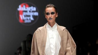 Sejumlah model saat menampilkan baju hasil rancangan desainer lokal dan International pada pembukaan Jakarta Fashion Week (JFW) 2019 di Senayan, Jakarta, Sabtu (20/10). (Suara.com/Fakhri Hermansyah)