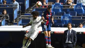 Bek Real Madrid Marcelo dan pemain depan Levante, Jason Remeseiro, melompat untuk memperebutkan bola selama pertandingan sepak bola liga Spanyol Real Madrid melawan Levante di Stadion Santiago Bernabeu, Madrid, Spanyol, Sabtu (20/10). [AFP/GABRIEL BOUYS]