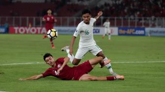 Pesepak bola Timnas Indonesia Saddil Ramdani dihalau dengan pesepak bola Qatar Abdullah Ali Saei dalam penyisihan Grup A Piala Asia U-19 di Stadion Utama Gelora Bung Karno, Jakarta, Minggu (21/10). [Suara.com/Muhaimin A Untung]