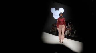 Model mengenakan pakaian rancangan desain Suqma saat hari jadi Mickey Mouse ke-90 di Jakarta Fashion Week 2019 di Senayan City, Jakarta, Senin (22/10). [Suara.com/Muhaimin A Untung]