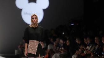 Model mengenakan pakaian rancangan desain Suqma saat hari jadi Mickey Mouse ke-90 di Jakarta Fashion Week 2019 di Senayan City, Jakarta, Senin (22/10). [Suara.com/Muhaimin A Untung]