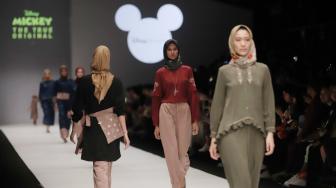 Model mengenakan pakaian rancangan desain Suqma saat hari jadi Mickey Mouse ke-90 di Jakarta Fashion Week 2019 di Senayan City, Jakarta, Senin (22/10). [Suara.com/Muhaimin A Untung]