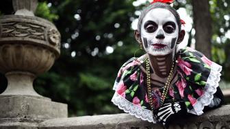 Seorang wanita menghias dirinya seperti seorang yang telah mati di perayaan Day of the Dead 2018 di kota Meksiko, Minggu (21/10). [Afp Photo/Rodrigo Arangua]