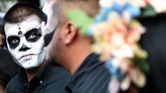 Seorang Pria menghias dirinya seperti seorang yang telah mati di perayaan Day of the Dead 2018 di kota Meksiko, Minggu (21/10). [Afp Photo/Rodrigo Arangua]