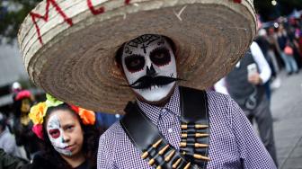 Seorang Pria menghias dirinya seperti seorang yang telah mati di perayaan Day of the Dead 2018 di kota Meksiko, Minggu (21/10). [Afp Photo/Rodrigo Arangua]