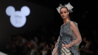 Model mengenakan pakaian rancangan desainer Didiet Maulana dari IKAT Indonesia saat peragaan busana Disney's Mickey Mouse: The True Orginal di Jakarta Fashion Week 2019 di Senayan City, Jakarta, Senin (22/10). [Suara.com/Muhaimin A Untung]