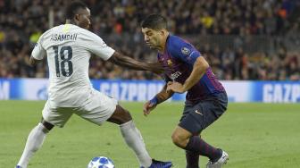 Bek  Inter Milan Kwadwo Asamoah mencoba menghadang pemain depan Barcelona Luis Suarez selama pertandingan Grup B Liga Champions Barcelona melawan Inter Milan di Stadion  Camp Nou, Barcelona, Spanyol, Rabu (24/10).  (AFP/LLUIS GENE)