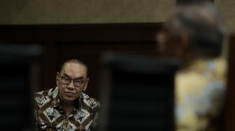 Terdakwa Johannes Budisutrisno Kotjo mendengarkan keterangan saksi pada sidang lanjutan kasus dugaan suap proyek PLTU Riau-1 di Pengadilan Tipikor, Jakarta, Kamis (25/10). [Suara.com/Muhaimin A Untung]
