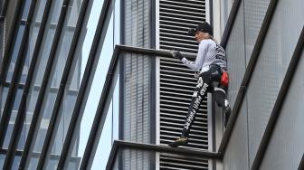 Pendaki Prancis Alain Robert, yang juga dikenal sebagai "Spider-Man", memanjat bagian Menara Heron di distrik keuangan London, Inggris, Kamis (25/10). [AFP/Daniel LEAL-OLIVAS]