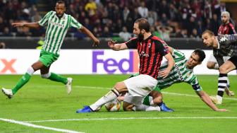 Bek Real Betis Aissa Mandi menghadang pemain depan AC Milan Gonzalo Higuain selama pertandingan Grup F Liga Europa antara AC Milan melawan Real Betis di Stadion San Siro, Milan, Italia, Kamis (25/10). [AFP/Miguel MEDINA]