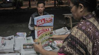 Loper koran saat menyusun Tabloid Olahraga Bola edisi terakhir yang akan dijual di kawasan Duren Sawit, Jakarta, Jumat (26/10). (Suara.com Fakhri Hermansyah)