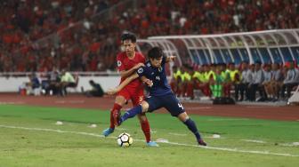 Pesepak bola Indonesia Hanis Saghara Putra berebut bola dengan pesepak bola Jepang Daiki Hashioka dalam babak perempat final Piala Asia U-19 di Stadion Utama Gelora Bung Karno, Senayan, Jakarta, Minggu (28/10/2018). [Suara.com/Muhaimin A Untung]