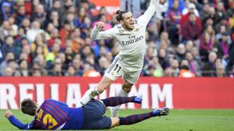 Bek Barcelona Gerard Pique menghadang pemain depan Real Madrid Gareth Bale saat pertandingan sepak bola liga Spanyol antara Barcelona melawan Real Madrid di Stadion Camp Nou, Barcelona, Spanyol, Rabu (28/10). [AFP/LLUIS GENE]