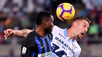 Gelandang Inter Milan Kwadwo Asamoah berusaha merebut bola dengan gelandang Lazio Sergej Milinkovic-Savic saat pertandingan sepak bola Liga Italia anatara Lazio melawan Inter Milan di Stadion Olimpico, Roma, Italia, Senin (29/10). [AFP/Alberto PIZZOLI] 