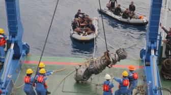 Petugas  kapal Baruna Jaya 1 mengangkat mesin turbin pesawat Lion Air JT 610  yang ditemukan oleh tim penyelam TNI AL Dislambair di perairan Karawang, Jawa Barat, Sabtu (3/11). (Suara.com/Fakhri Hermansyah)