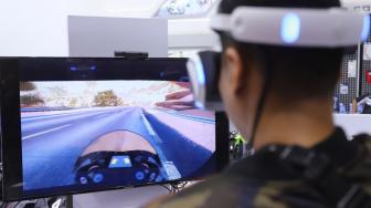 Seorang pengunjung bermain permainan balap motor menggunakan Virtual Reality di VR Corner saat pagelaran Indonesia Motorcycle Show (IMOS) 2018, JCC Senayan, Jakarta, Minggu (4/11/2018). [Suara.com/Muhaimin A Untung] 