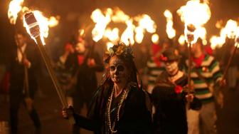 Warga berparade dengan membawa obor dalam perayaan Guy Fawkes Night atau juga disebut Bonfire Night di Lewes, Inggris, Senin (5/11). [AFP/Daniel LEAL-OLIVAS]