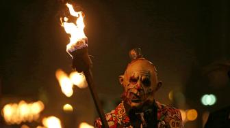 Warga berparade dengan membawa obor dalam perayaan Guy Fawkes Night atau juga disebut Bonfire Night di Lewes, Inggris, Senin (5/11). [AFP/Daniel LEAL-OLIVAS]