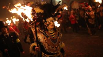 Warga berparade dengan membawa obor dalam perayaan Guy Fawkes Night atau juga disebut Bonfire Night di Lewes, Inggris, Senin (5/11). [AFP/Daniel LEAL-OLIVAS]