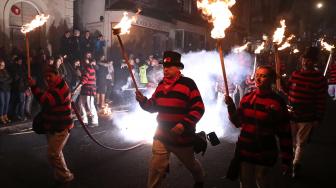 Warga berparade dengan membawa obor dalam perayaan Guy Fawkes Night atau juga disebut Bonfire Night di Lewes, Inggris, Senin (5/11). [AFP/Daniel LEAL-OLIVAS]