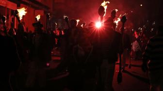 Warga berparade dengan membawa obor dalam perayaan Guy Fawkes Night atau juga disebut Bonfire Night di Lewes, Inggris, Senin (5/11). [AFP/Daniel LEAL-OLIVAS]