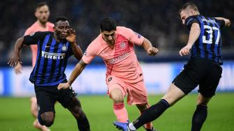 Pemain depan Barcelona Luis Suarez mencoba melewati gelandang Inter Milan Kwadwo Asamoah dan bek Inter Milan Skriniar selama pertandingan Grup B Liga Champions Inter Milan melawan Barcelona di Stadion Giusepe Meazza, Milan, Italia, Rabu (7/11). [AFP/Marco BERTORELLO]