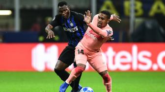 Gelandang Inter Milan Kwadwo Asamoah dan gelandang Barcelona Malcom bertarung memperebutkan bola selama pertandingan Grup B Liga Champions Inter Milan melawan Barcelona di Stadion Giusepe Meazza, Milan, Italia, Rabu (7/11). [AFP/Miguel MEDINA]