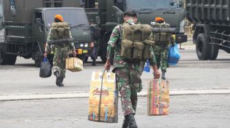 Sejumlah anggota TNI memindahkan barang perlengkapannya ke dalam bus saat tiba di Pelabuhan Tanjung Priok, Jakarta Utara, Kamis (8/11). (Suara.com/Fakhri Hermansyah)