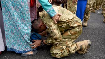 Seorang prajurit TNI AL yang tergabung dalam Satgas Maritim Task Force (MTF) Konga XXVIII.J UNIFIL mencium kaki ibunya ketika tiba di Dermaga Ujung Koarmada II Surabaya, Jawa Timur, Kamis (8/11). [ANTARA FOTO/M Risyal Hidayat]