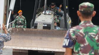 Sejumlah anggota TNI mengeluarkan mesin alat berat dari kapal saat tiba di Pelabuhan Tanjung Priok, Jakarta Utara, Kamis (8/11). (Suara.com/Fakhri Hermansyah)